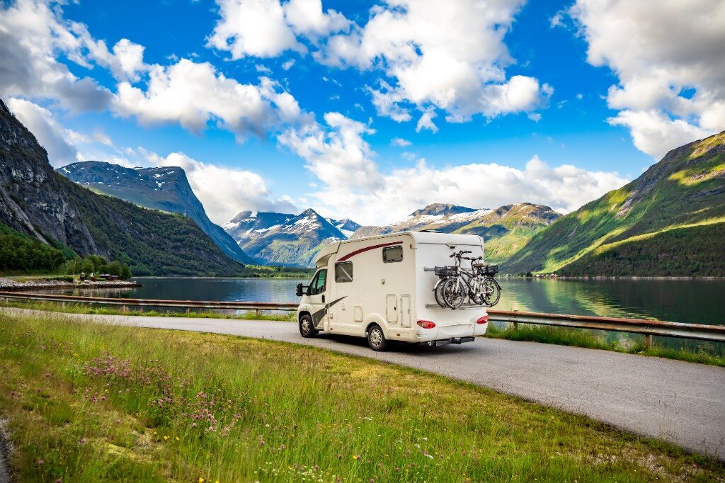 Motorisé devant un lac et des montagnes pour planifier un séjour en camping